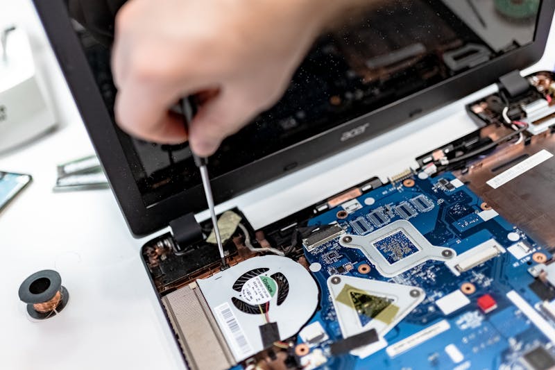 cleaning laptop ambient light sensor near webcam, technician repairing display hardware