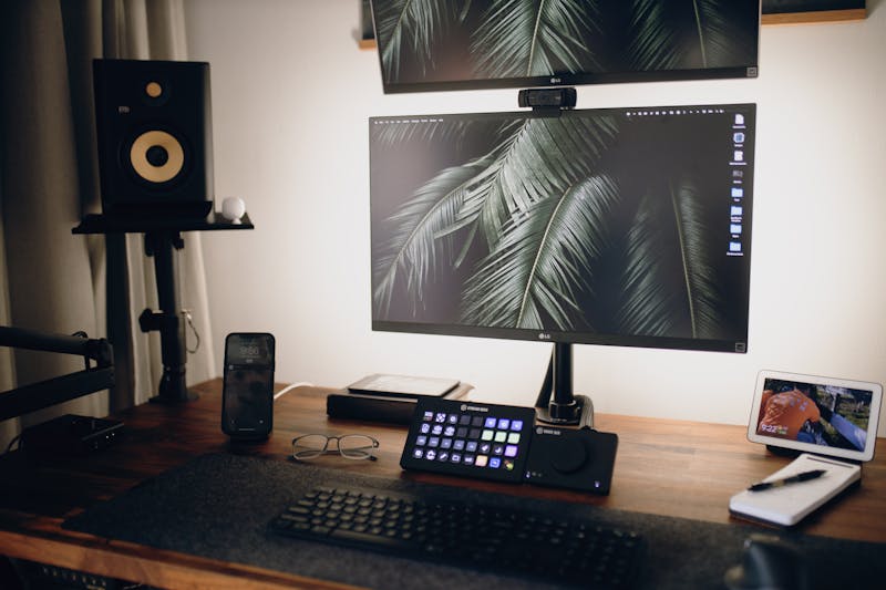 setup profissional de home office com múltiplos monitores configurados para streaming de alta definição