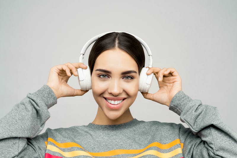 person wearing headphones looking confused, split screen left right audio waves, dark tech background