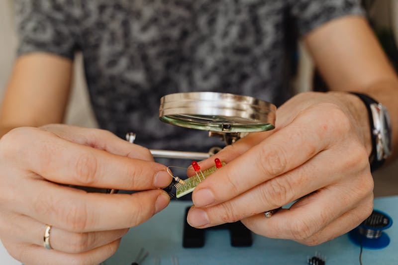 technician using multimeter to check vibration motor circuit on disassembled phone