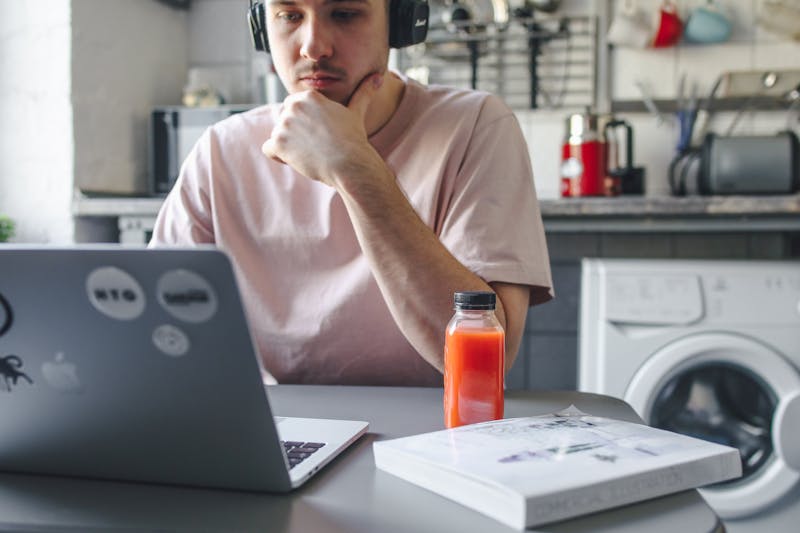 онлайн конференция, настройка микрофона, визуализация звуковой волны, человек в наушниках за ноутбуком, минимализм