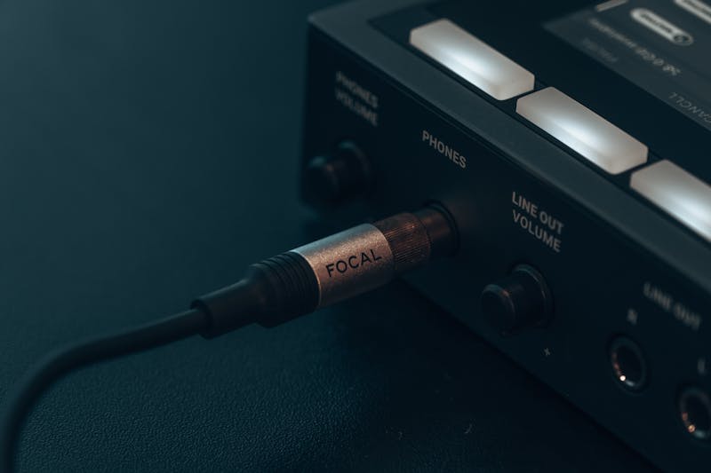 close up of audio cable plugged into laptop, split left right sound visualization diagram