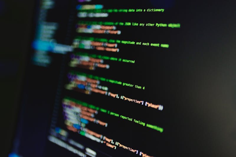 closeup macro shot of monitor screen showing a single bright green stuck pixel against a black background